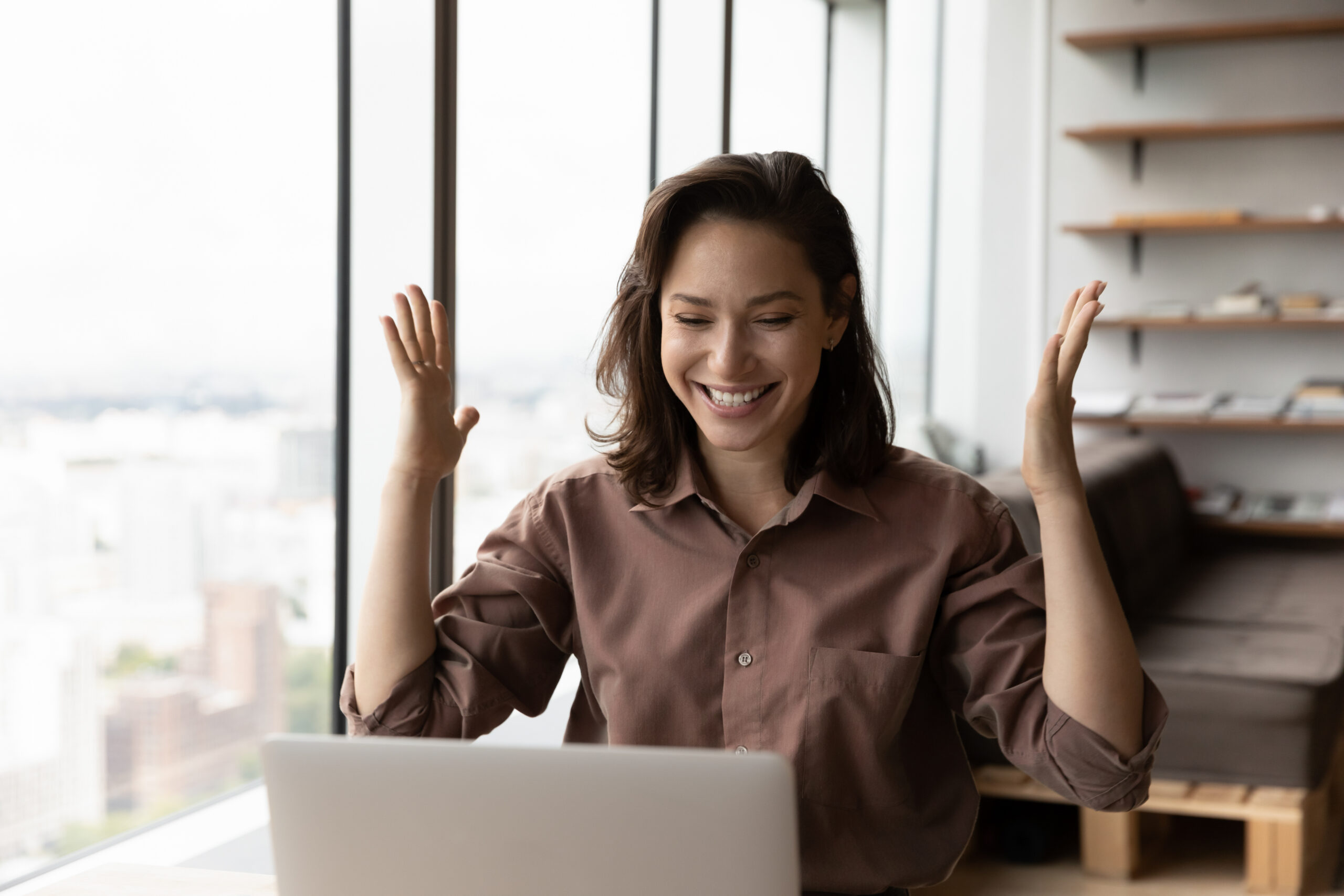 Woman celebrating financial relief on laptop – file bankruptcy online from home with Merna Law Virginia